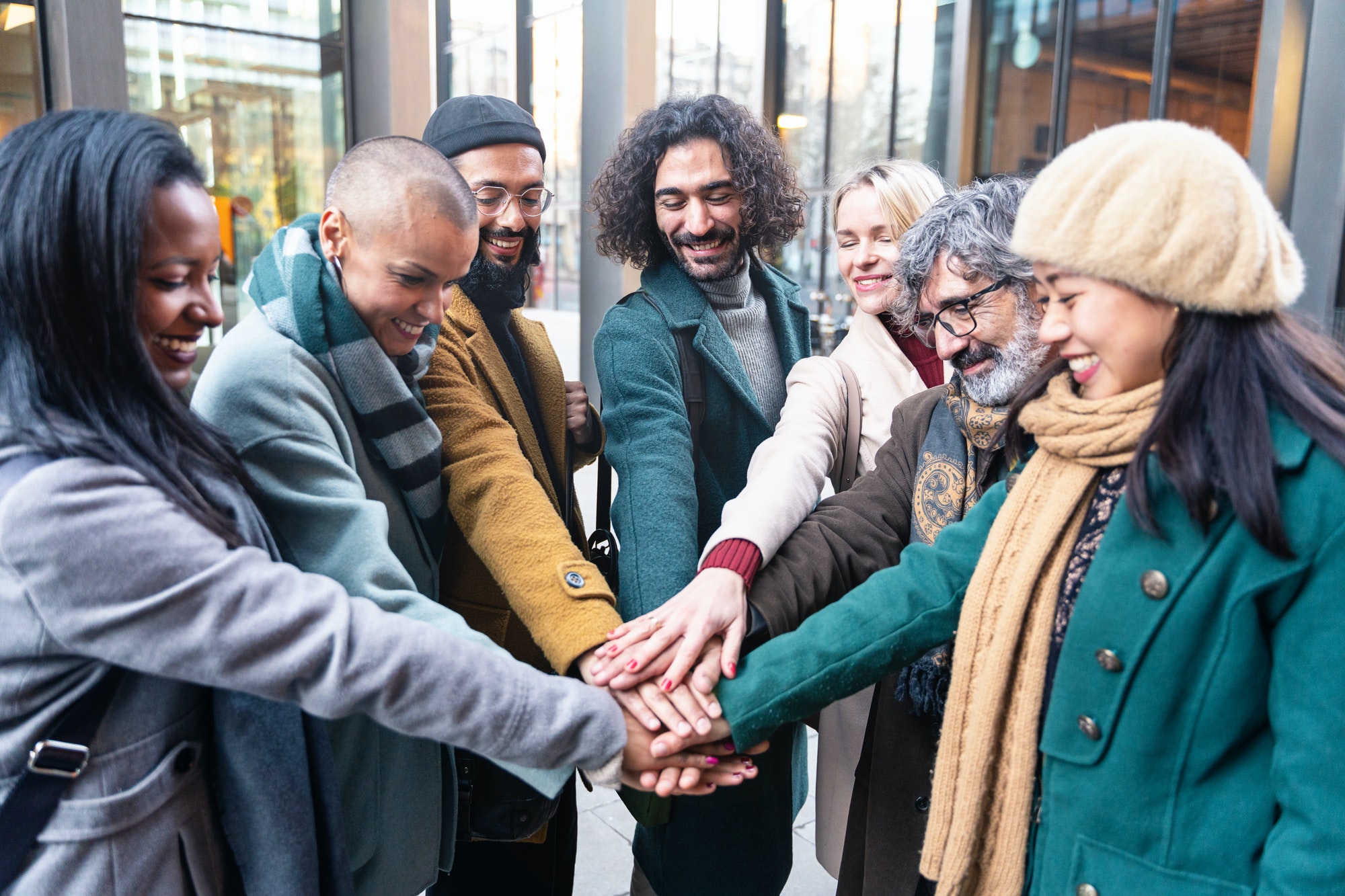 Group Group of positive professional coworker people stacking hands outside workplace