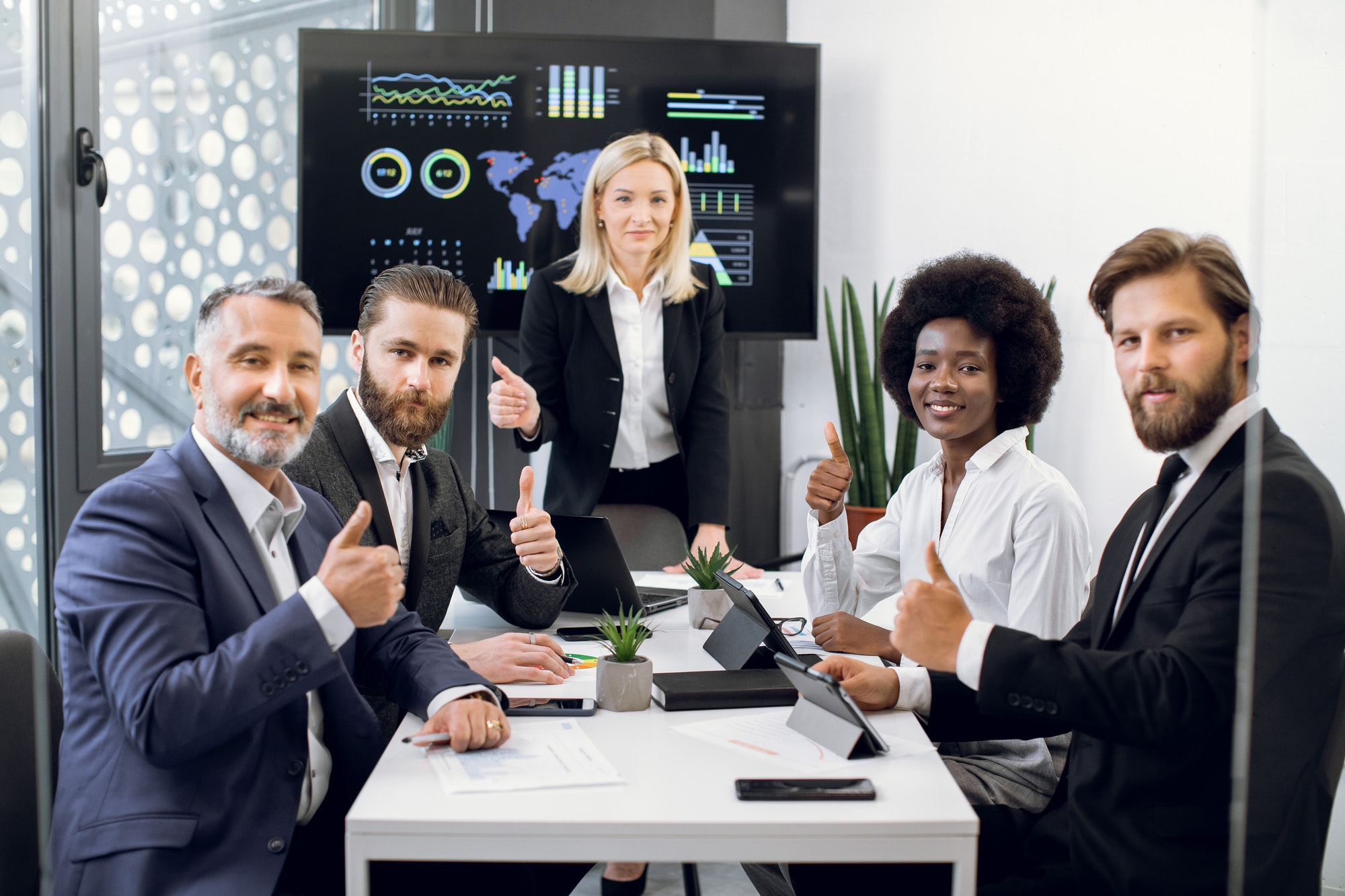 Team of professional high-skilled multiethnical team of business men and women, sitting at the table